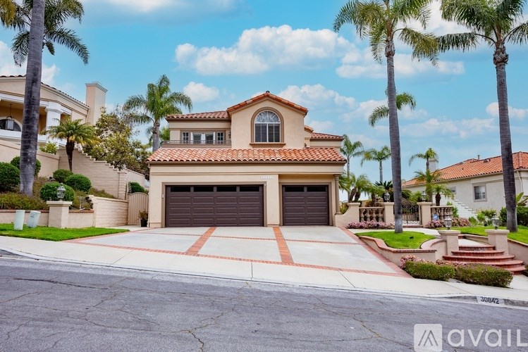 A house with a red tiled roof and a garage door is for sale.