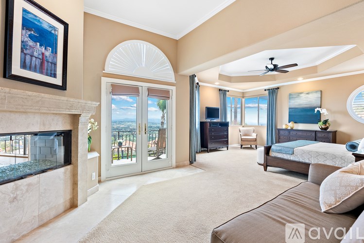 A bedroom with a large bed and a fireplace.