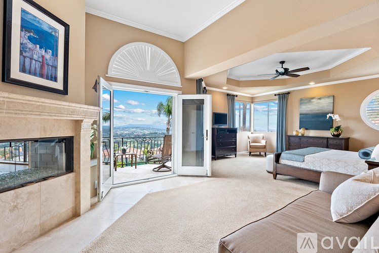 A bedroom with a large bed and a fireplace.