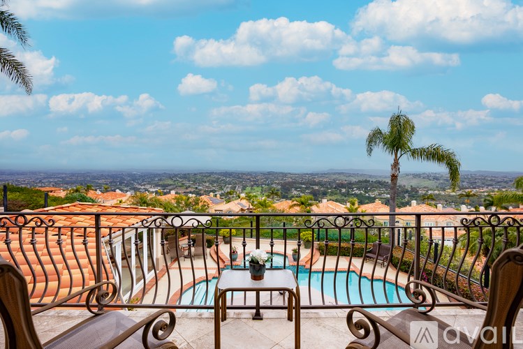 A pool surrounded by a metal fence with a palm tree in the background.