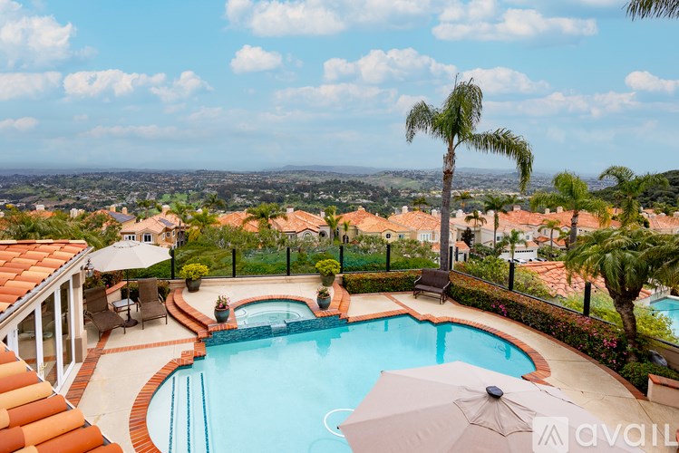 A pool surrounded by a patio and a view of the city.