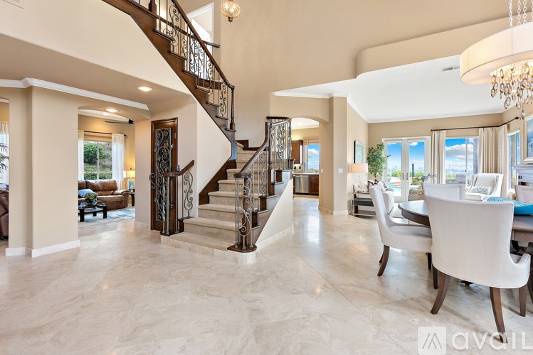 A spacious living room with a staircase and a dining area.