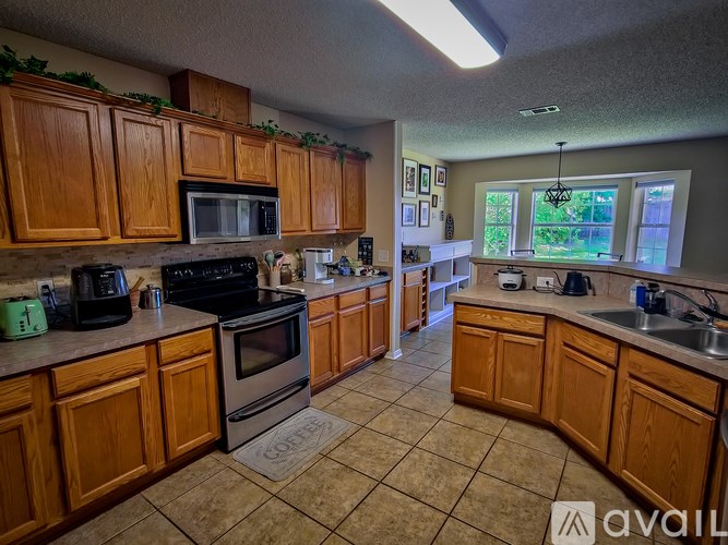 A kitchen with wooden cabinets and tile flooring.
