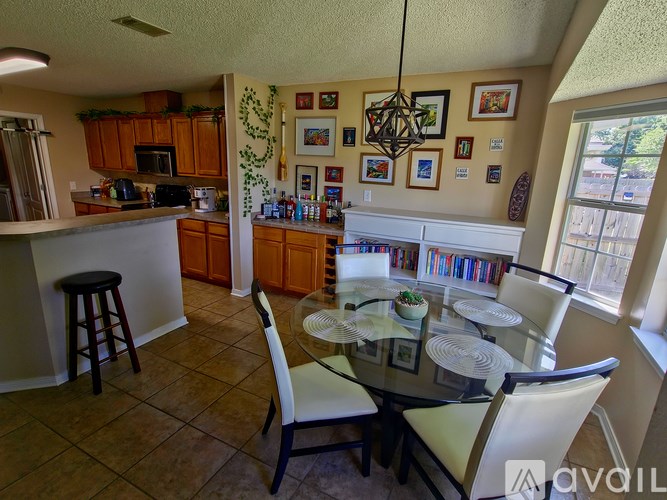 A kitchen with a dining table and chairs.