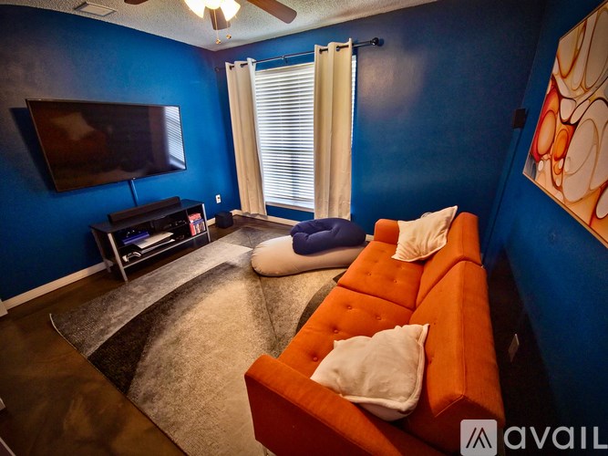A living room with a blue wall and an orange couch.