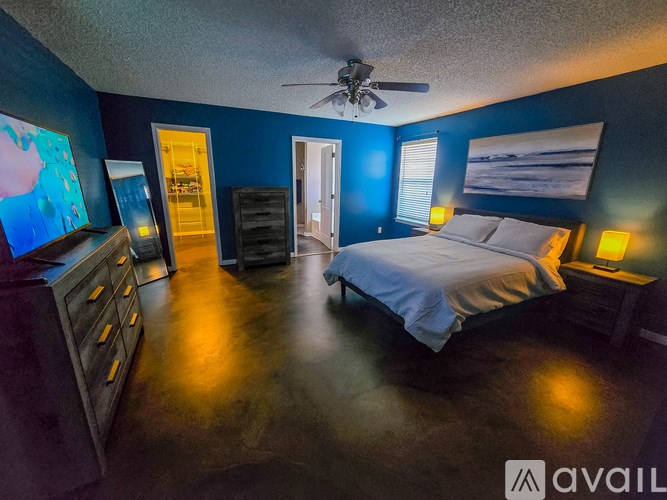 A bedroom with a bed, dresser, and ceiling fan.