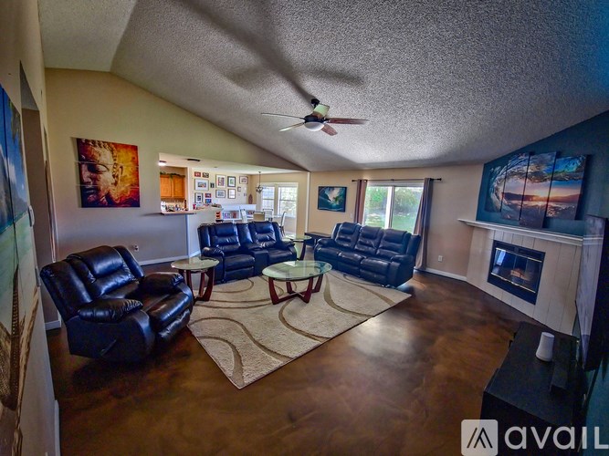 A living room with a fireplace and a ceiling fan.
