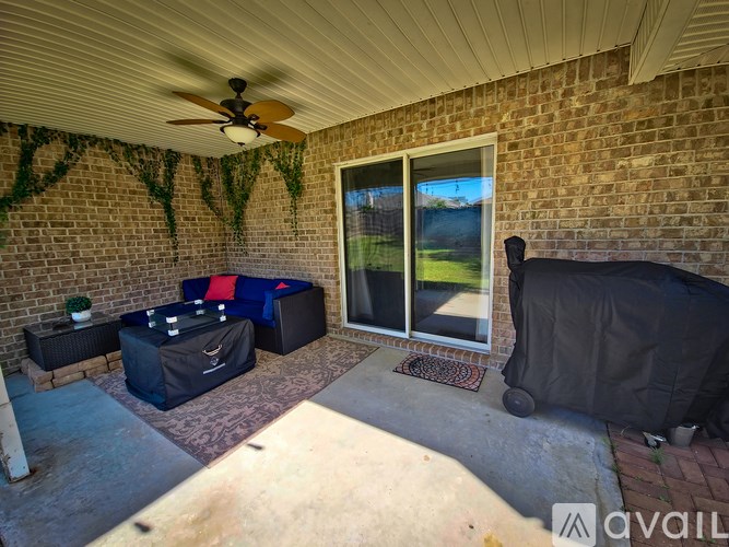 A patio with a ceiling fan and a covered table.