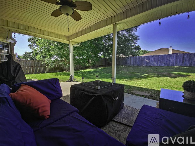 A patio with a ceiling fan and a black suitcase on the floor.