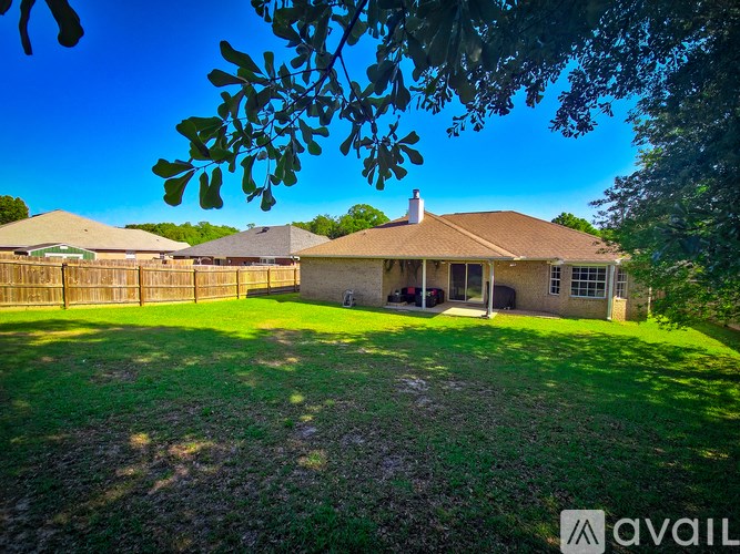 A house with a brown roof and a fence in front of it.