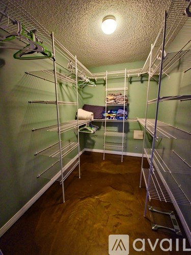 A room with a lot of shelves and a bed in the corner.