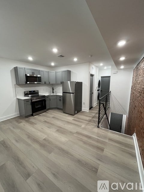 A kitchen with a refrigerator, stove, and cabinets.