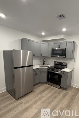 A kitchen with a stainless steel refrigerator, microwave, oven, and cabinets.