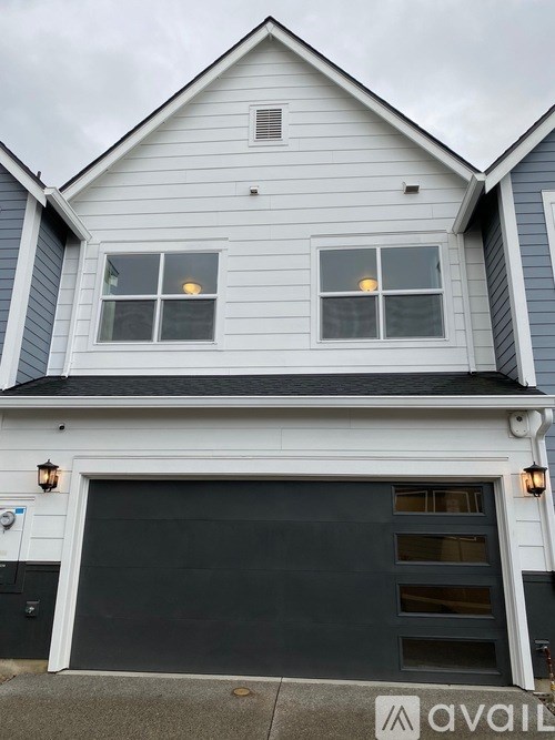A two-story house with a garage door.