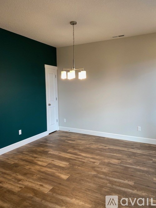 A room with wooden flooring and a white door.