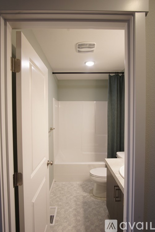 A bathroom with a toilet, sink and shower.