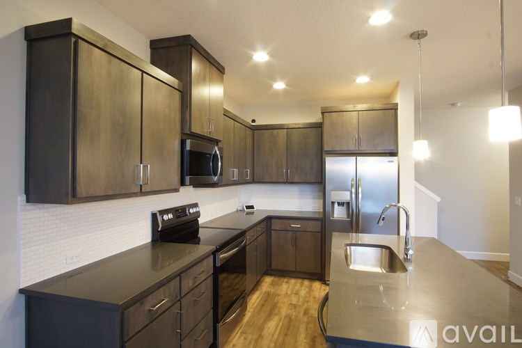 A kitchen with dark wood cabinets and stainless steel appliances.