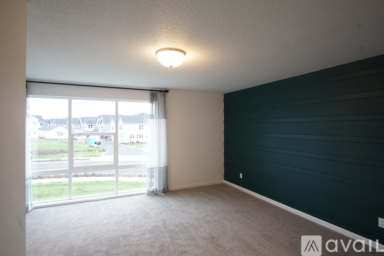 A room with a carpeted floor and a window with blinds.