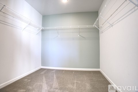 A sparsely furnished room with a carpeted floor and white walls.