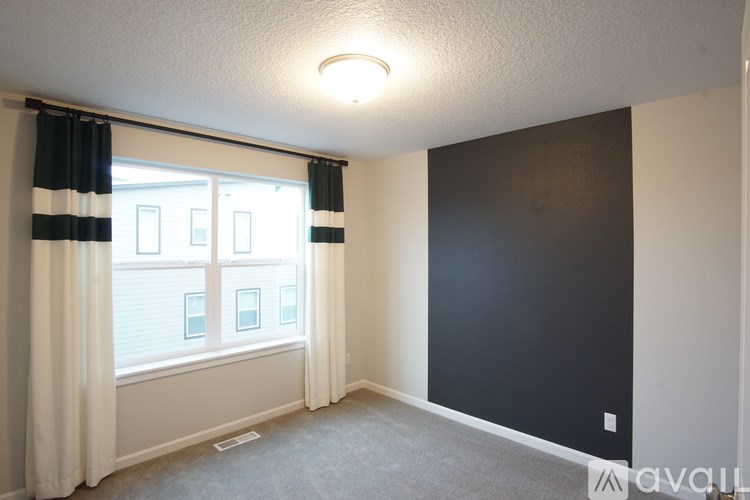 A room with a window and curtains.