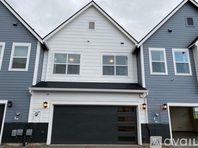 A two-story house with a garage and a white front door.