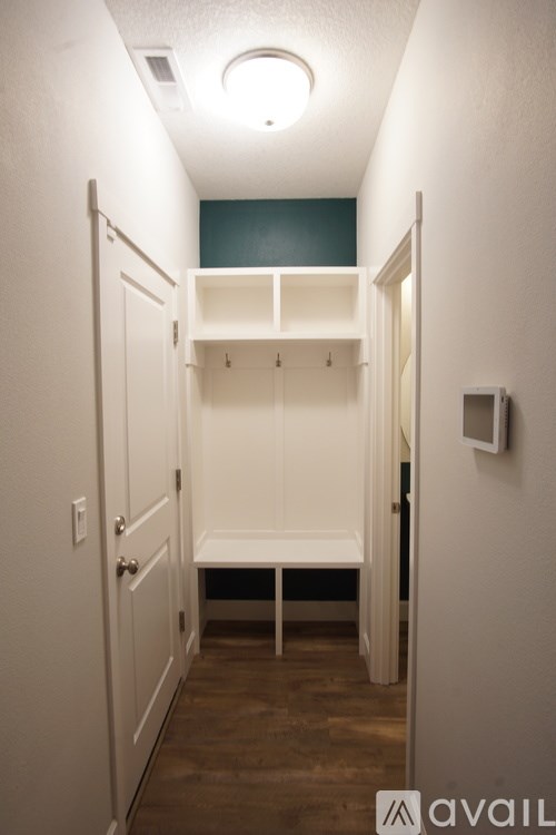 A white closet with a bench and shelves.