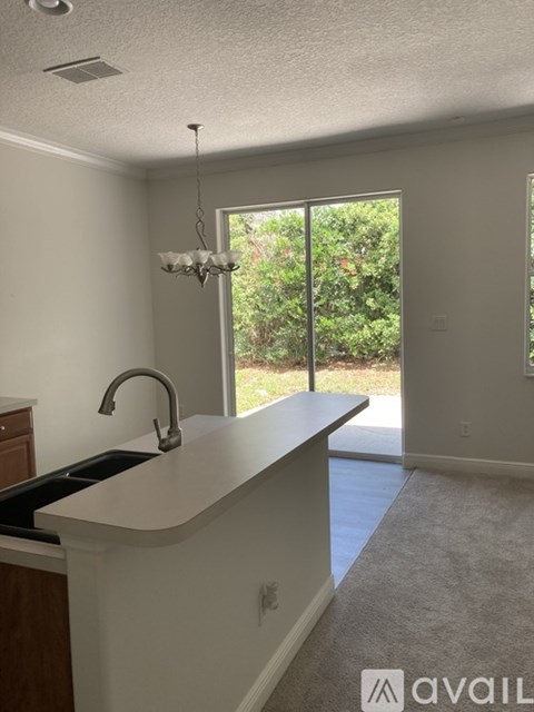A kitchen with a sink and a chandelier.