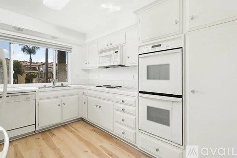 A kitchen with white appliances and cabinets.