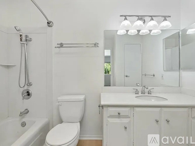 A white bathroom with a toilet, sink, and bathtub.
