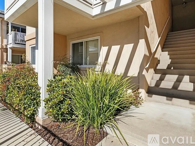 A house with a front yard and a staircase leading to the entrance.