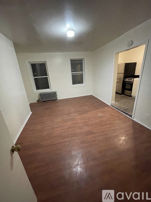 A room with wooden flooring and a radiator.