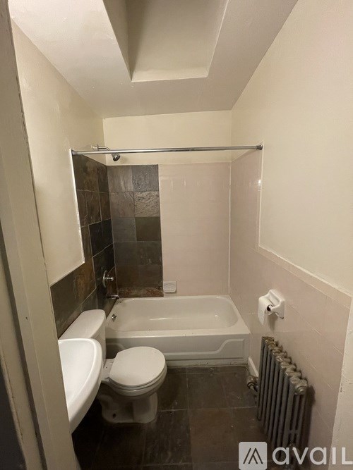 A bathroom with a toilet, sink, and bathtub.