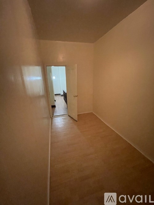 A hallway with a cat sitting on the floor.
