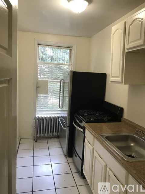 A kitchen with black appliances and white cabinets.
