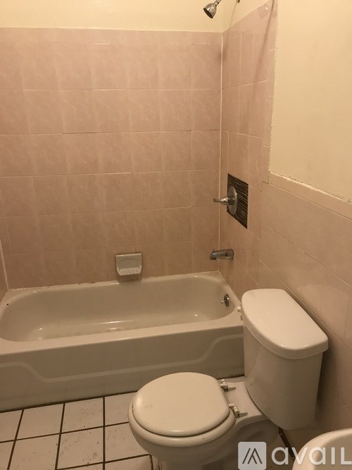 A white toilet sits next to a bathtub in a bathroom.