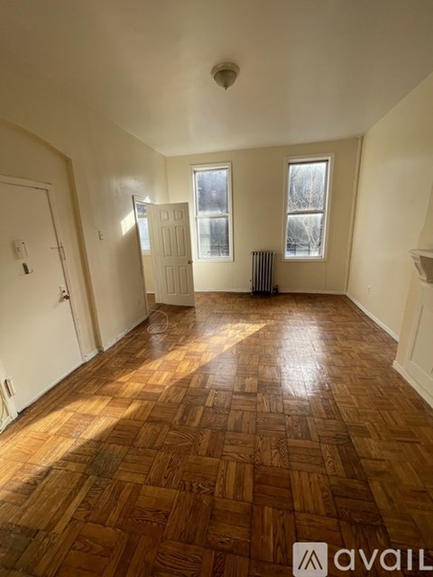 A room with wooden flooring and white walls.