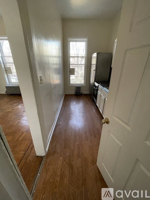 A hallway with wood floors and white walls.