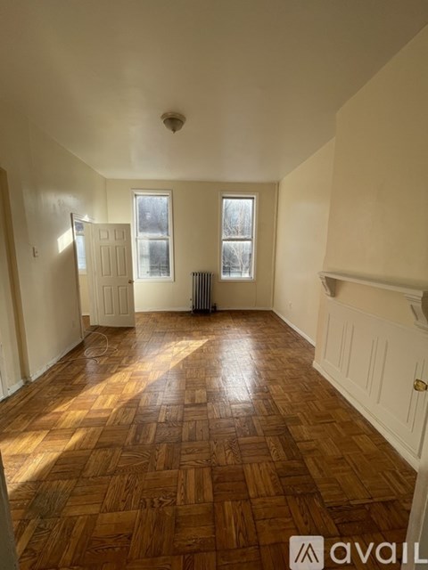 A room with wooden flooring and white walls.
