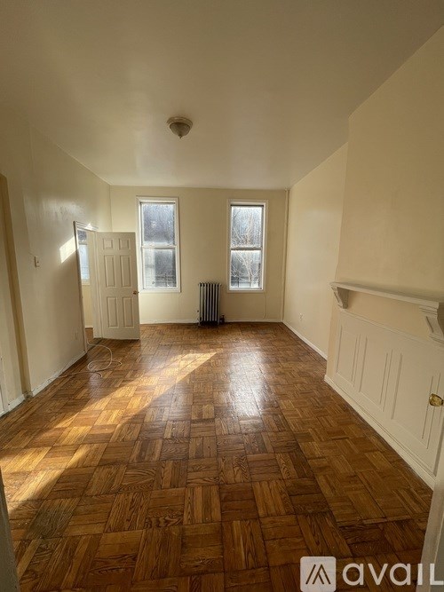 A room with wooden flooring and white walls.