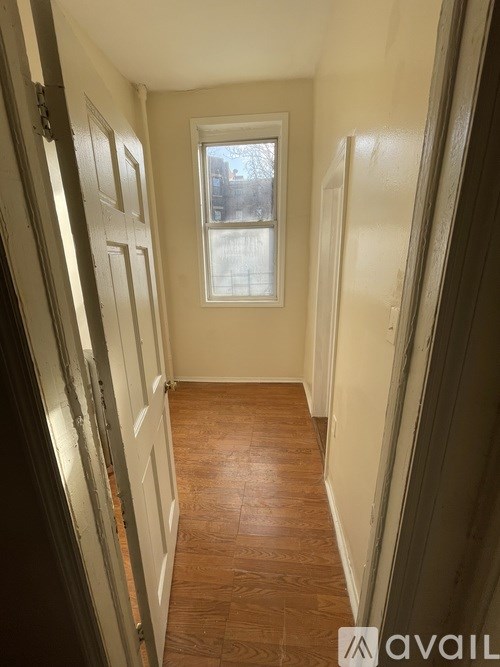 A hallway with wooden floors and white doors.