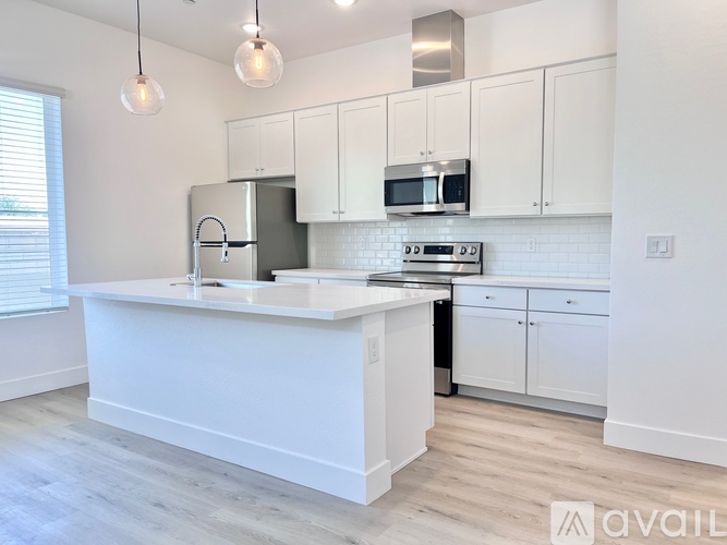 A kitchen with white cabinets and a black dishwasher.