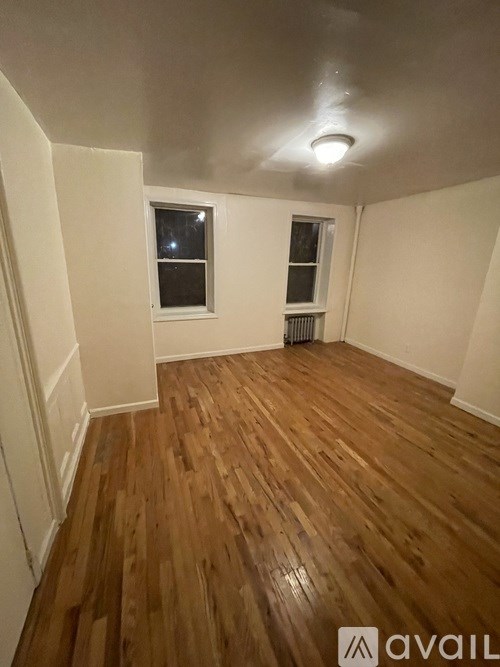 A room with wooden flooring and a window.