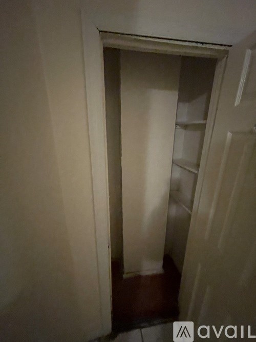 A small, dark room with a doorway leading to another room.
