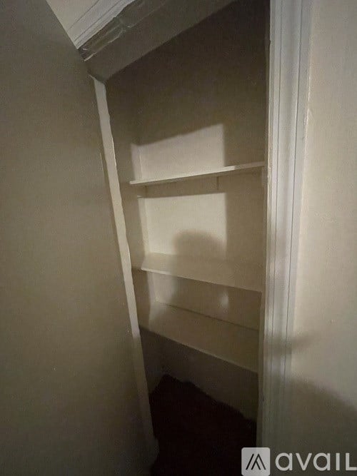 A white shelving unit in a corner of a room.