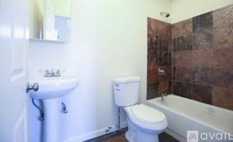 A bathroom with a toilet, sink, and bathtub.