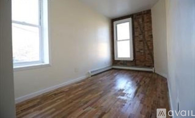 A room with wooden flooring and a window.