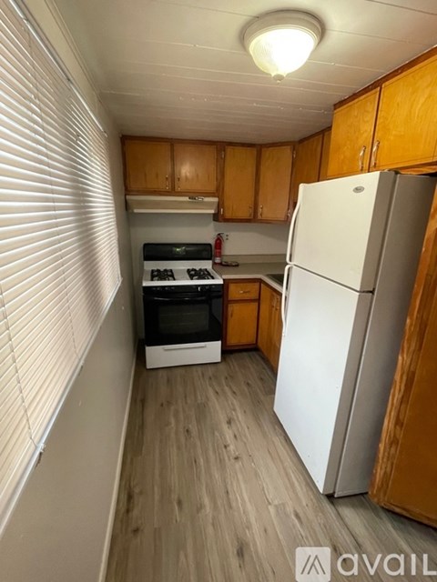 A kitchen with wooden cabinets and a white refrigerator.