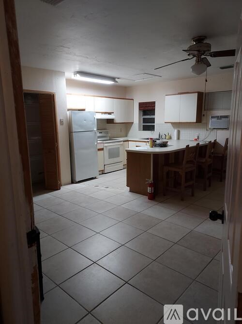 A kitchen with a refrigerator, microwave, and oven.