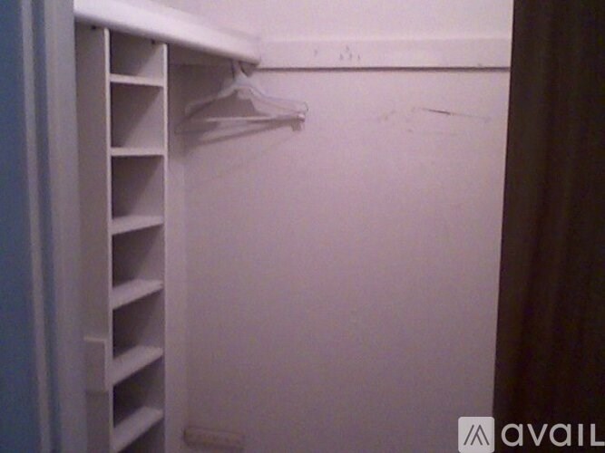 A white closet with a hanger on the rail.