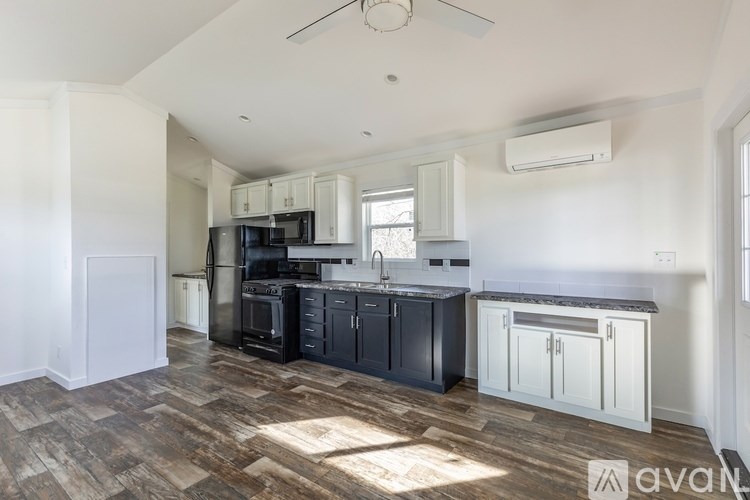 A kitchen with a wooden floor and white walls.